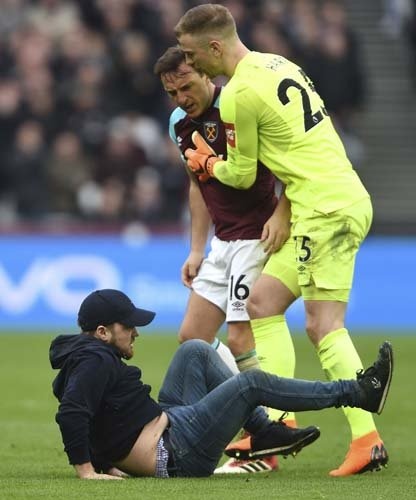 Yerde yatan taraftara bağırmaya devam eden ve üzerine yürüyen Mark Noble'ı kaleci Hart zorlukla durdu.